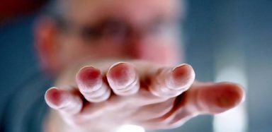 Een hand met uitgestoken vingers gericht naar de camera.